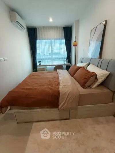 Cozy bedroom with modern decor and large window for natural light.