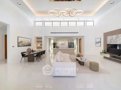 Luxurious open-plan living room with modern kitchen and elegant dining area, featuring high ceilings and stylish lighting.