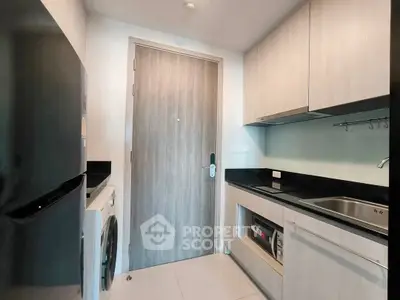 Modern kitchen with sleek cabinetry and built-in appliances in a compact layout.