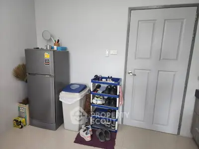 Compact storage area with fridge and shoe rack in modern home