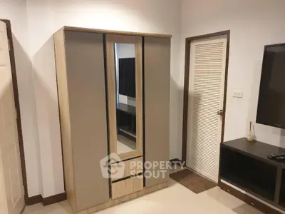 Modern bedroom with sleek wardrobe and TV unit, perfect for stylish living.