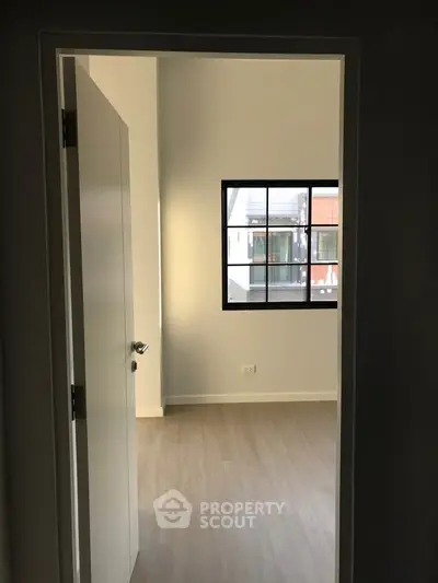 Modern minimalist room with wooden flooring and large window