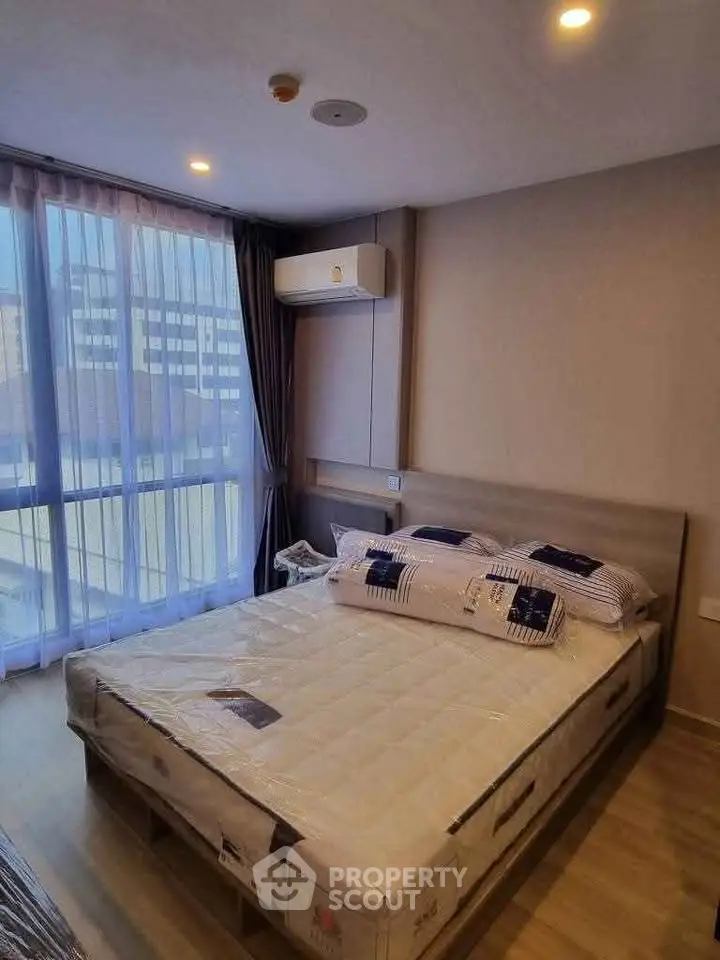 Modern bedroom with large window and air conditioning in urban apartment