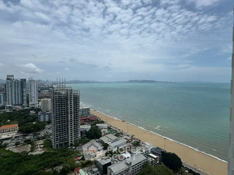 Stunning beachfront view from high-rise building overlooking ocean and cityscape.