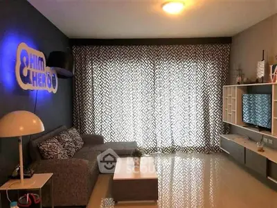 Modern living room with stylish decor and large window drapes, featuring a cozy gray sofa and sleek entertainment unit.