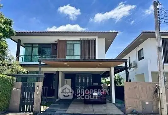 Modern two-story house with carport and sleek design in a suburban neighborhood.