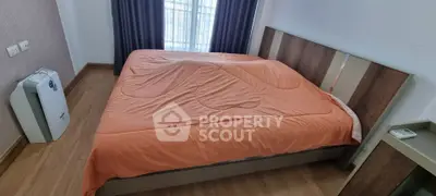 Cozy bedroom with large bed and air purifier, featuring wooden flooring and modern design.