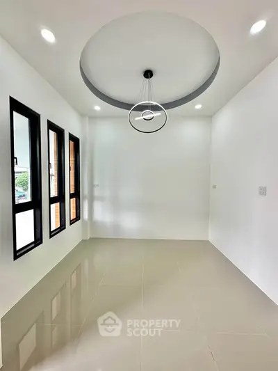 Modern minimalist room with stylish ceiling light and large windows