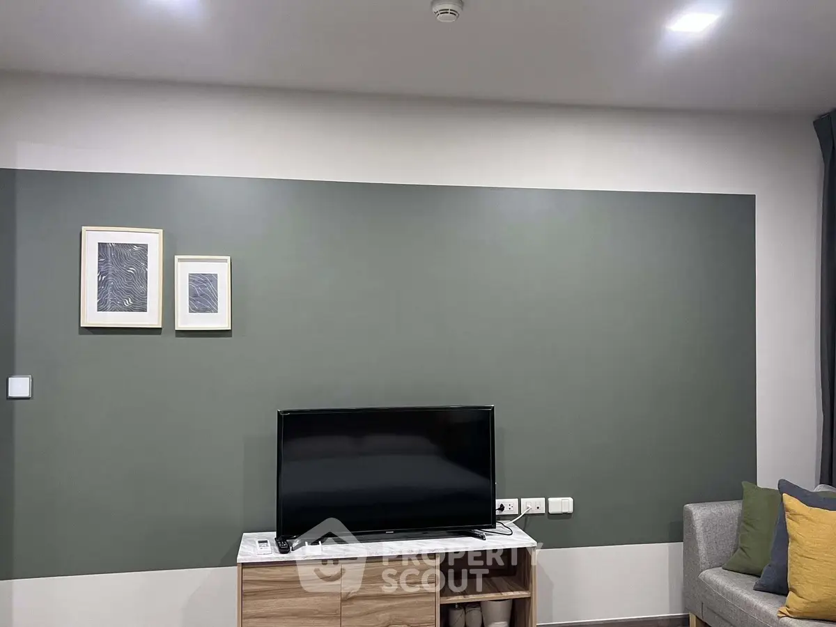 Modern living room with stylish decor and flat-screen TV, perfect for relaxation and entertainment.