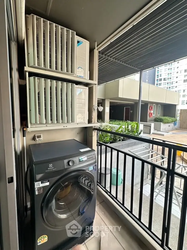 Modern apartment balcony with washing machine and air conditioning units, offering urban convenience and functionality.