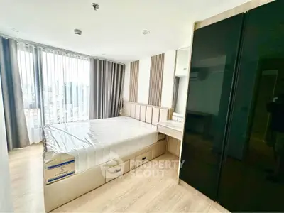 Modern bedroom with large windows and sleek furniture in a high-rise apartment.
