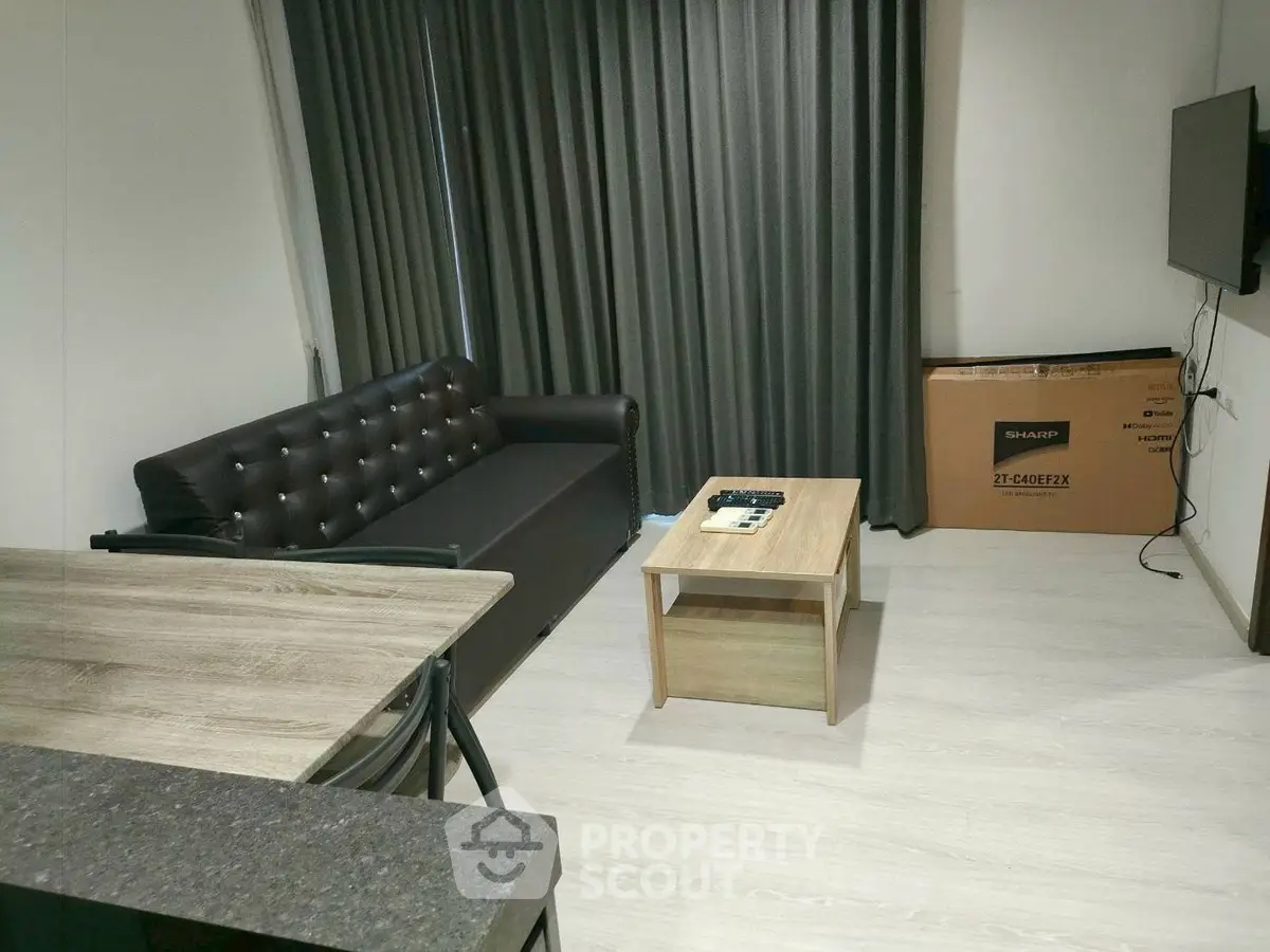 Modern living room with sleek sofa, wall-mounted TV, and stylish coffee table in a cozy apartment.