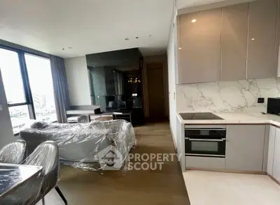 Modern open-plan living room and kitchen with sleek design and natural light.