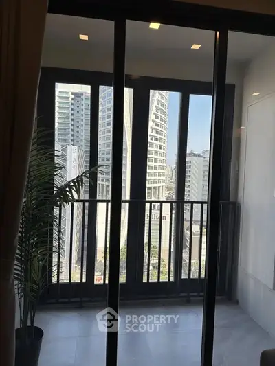 Modern apartment balcony with city view and large glass doors