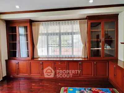 Elegant wooden built-in cabinets in a spacious living room with polished hardwood floors.