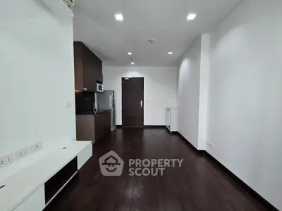 Modern apartment interior with sleek kitchen and dark wood flooring, perfect for urban living.