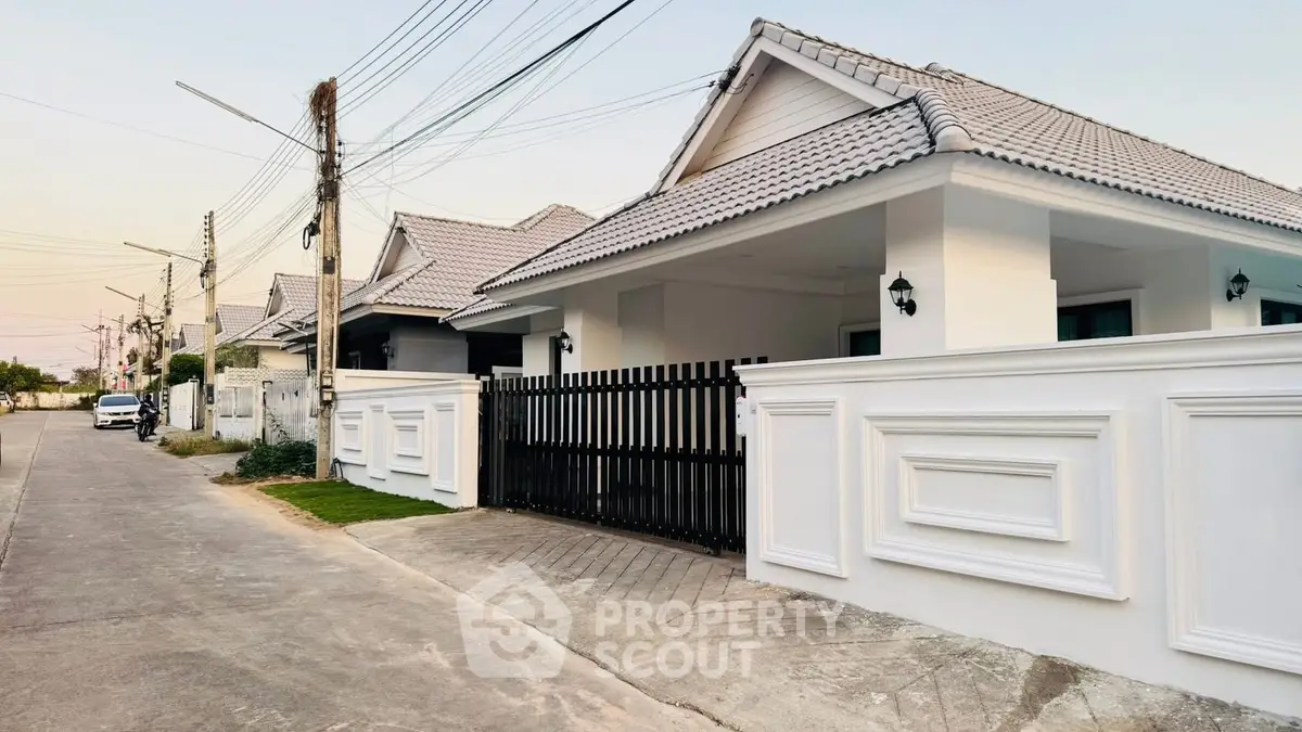 Charming suburban house with modern white facade and gated entrance