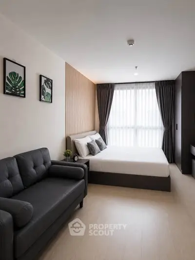 Modern bedroom with stylish decor and natural light, featuring a cozy sofa and elegant curtains.
