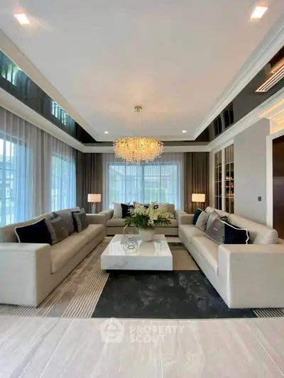 Luxurious living room with elegant chandelier and modern decor in a spacious home.