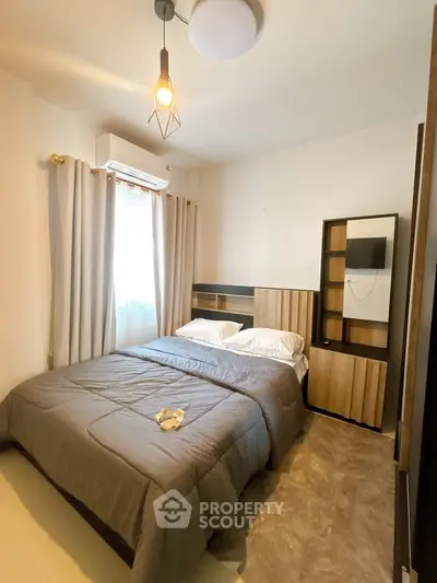 Cozy bedroom with modern decor and ample natural light, featuring a stylish bed and elegant furnishings.