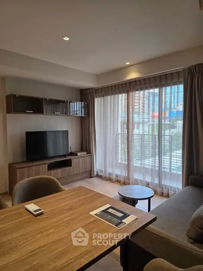 Modern living room with large windows and stylish furniture in a city apartment.