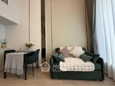 Stylish modern living room with cozy green sofa and elegant dining area