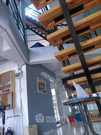Modern industrial-style interior with wooden staircase and open layout