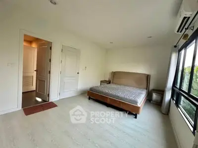 Spacious bedroom with large window and modern decor