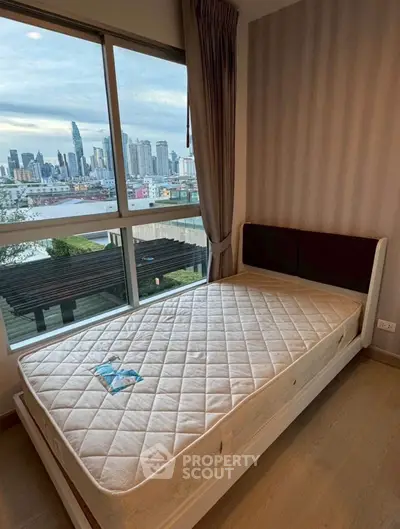 Cozy bedroom with stunning city skyline view through large window, featuring a comfortable bed and elegant decor.