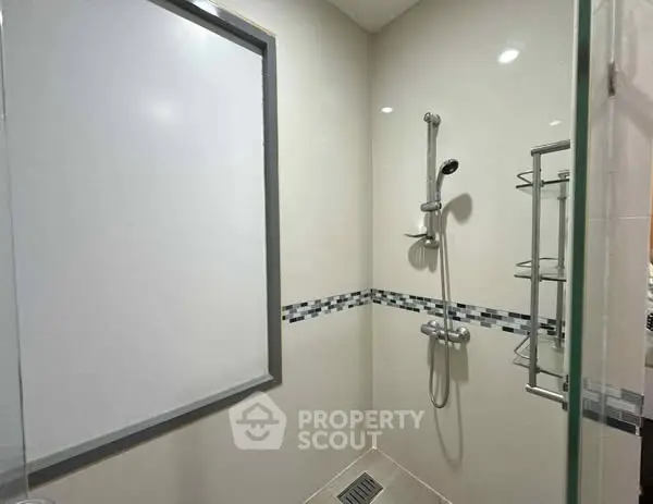 Modern bathroom with sleek shower design and elegant tile accents.