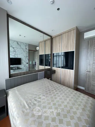 Modern bedroom with stylish wooden wardrobe and large mirror, featuring a cozy bed and sleek TV setup.