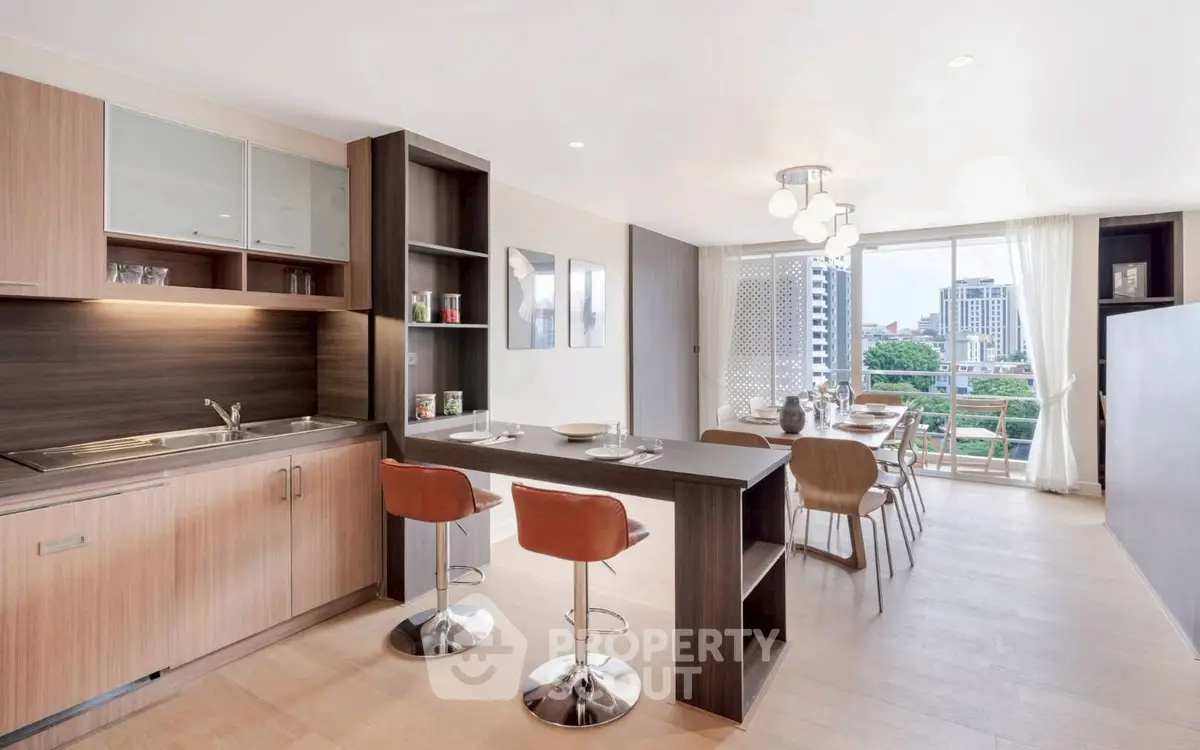 Modern open-layout kitchen and dining area with city view balcony