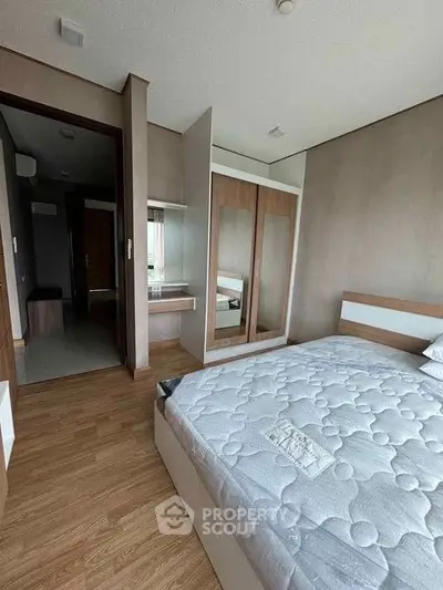 Modern bedroom with wooden flooring and built-in wardrobe in a stylish apartment.