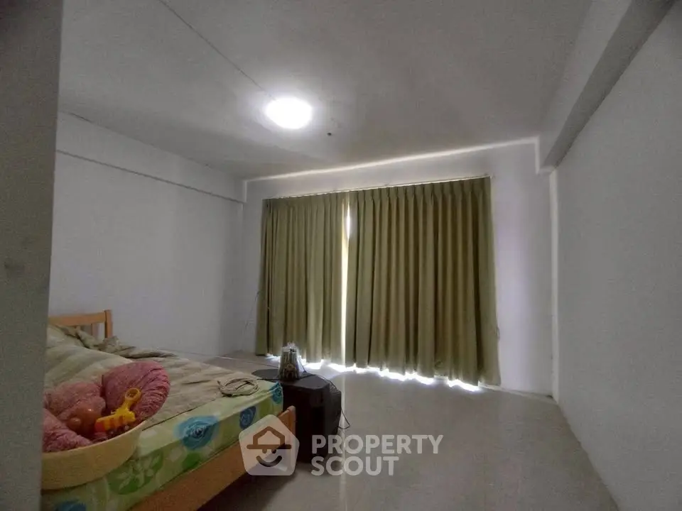 Spacious bedroom with natural light and minimalist decor, perfect for relaxation.