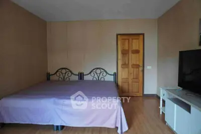 Spacious bedroom with wooden flooring and modern furnishings