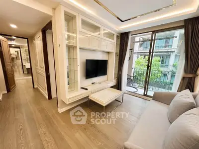 Elegant living room with modern decor and large window overlooking a balcony with greenery.