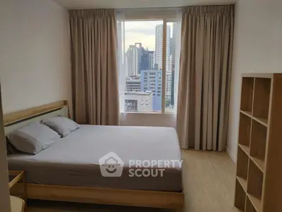 Modern bedroom with city view, featuring a cozy bed and stylish shelving unit, perfect for urban living.