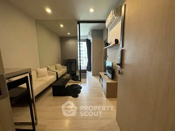 Modern living room with sleek design and large mirror enhancing space