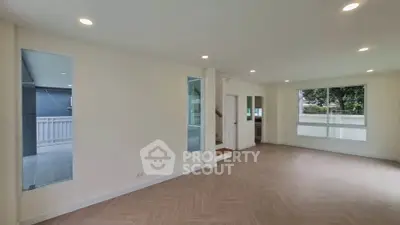 Spacious modern living room with large windows and elegant flooring