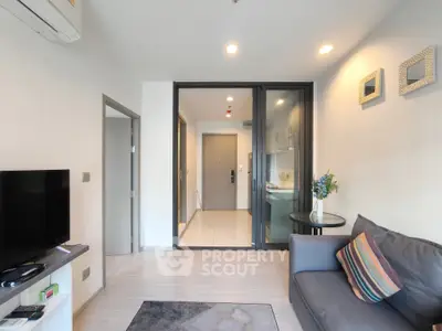 Modern living room with stylish decor and open layout, featuring a cozy sofa and sleek TV setup.