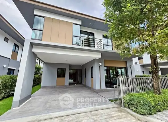 Modern two-story house with spacious driveway and lush greenery, perfect for family living.