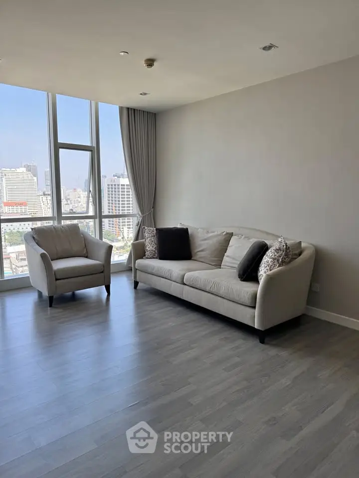 Spacious living room with modern furniture and city view, perfect for urban living.