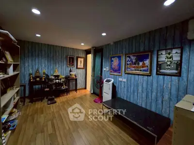 Charming room with wooden flooring and blue accent wall, adorned with art and decor, perfect for a cozy living space.