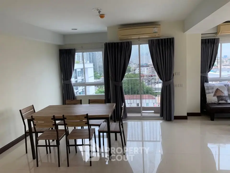 Spacious living room with dining area and city view in modern apartment.