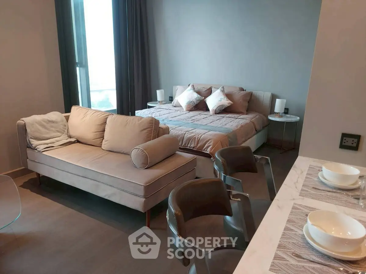 Modern studio apartment with cozy bed and stylish seating area