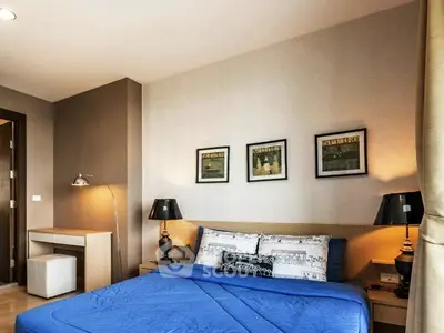 Stylish bedroom with modern decor and cozy blue bedding in a contemporary apartment.