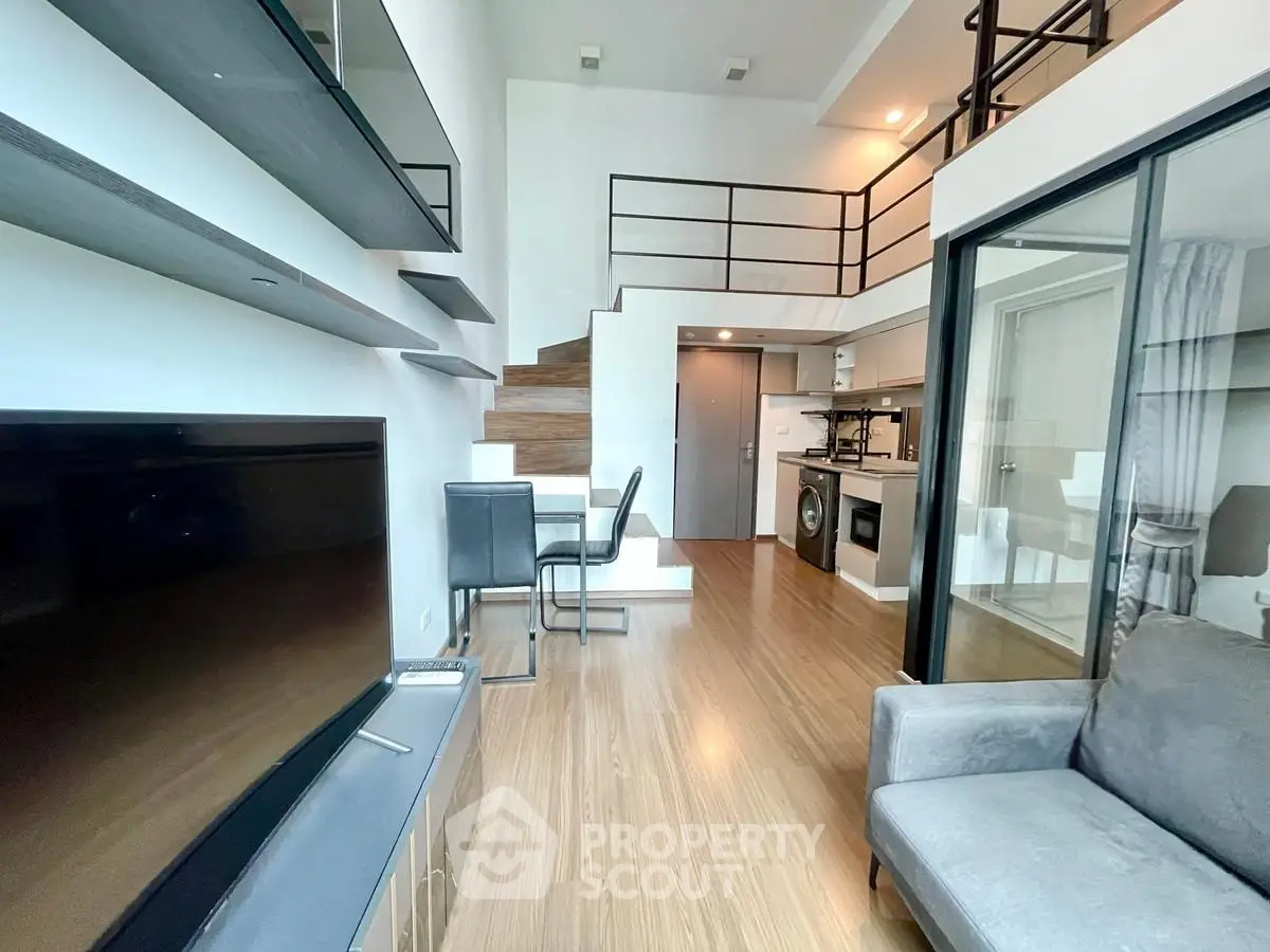 Modern loft apartment with sleek design and open layout, featuring a stylish staircase and cozy living area.