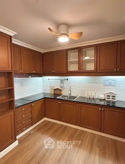 Charming kitchen with wooden cabinets and modern lighting, perfect for culinary enthusiasts.