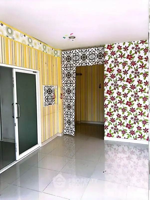 Vibrant interior with floral and striped wallpaper, sliding glass doors, and glossy tiled floor.