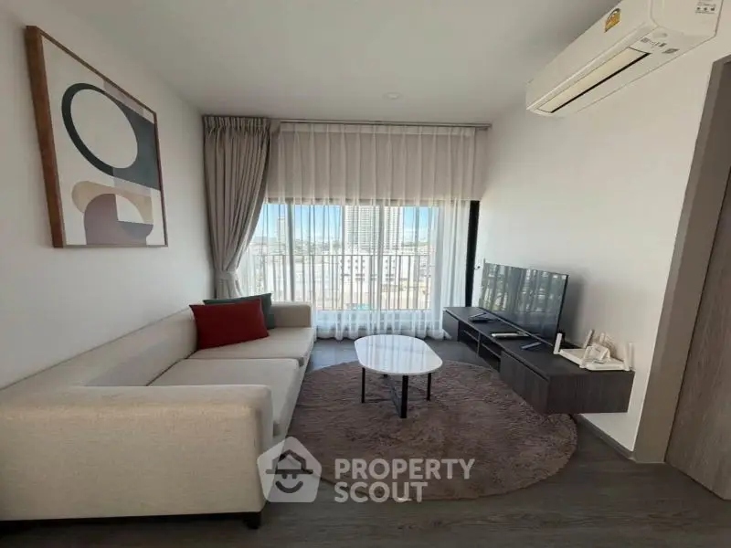 Modern living room with stylish decor and city view, featuring a cozy sofa and wall-mounted TV.